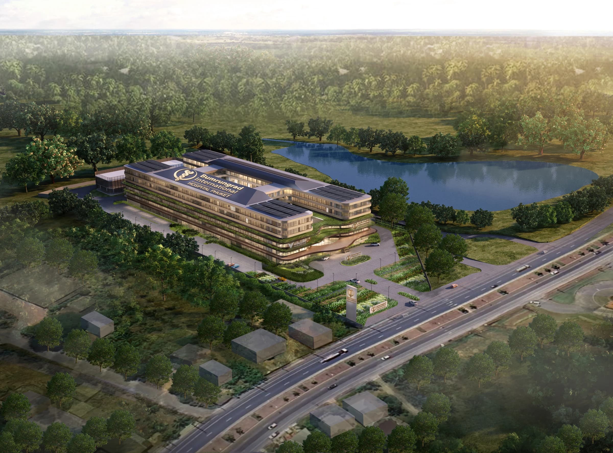 Aerial architectural rendering of Bumrungrad International Hospital Phuket beside a lake, with landscaped grounds and an entrance forecourt.